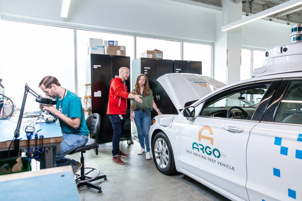 robotics engineers review a self-driving autonomous vehicle, argo ai
