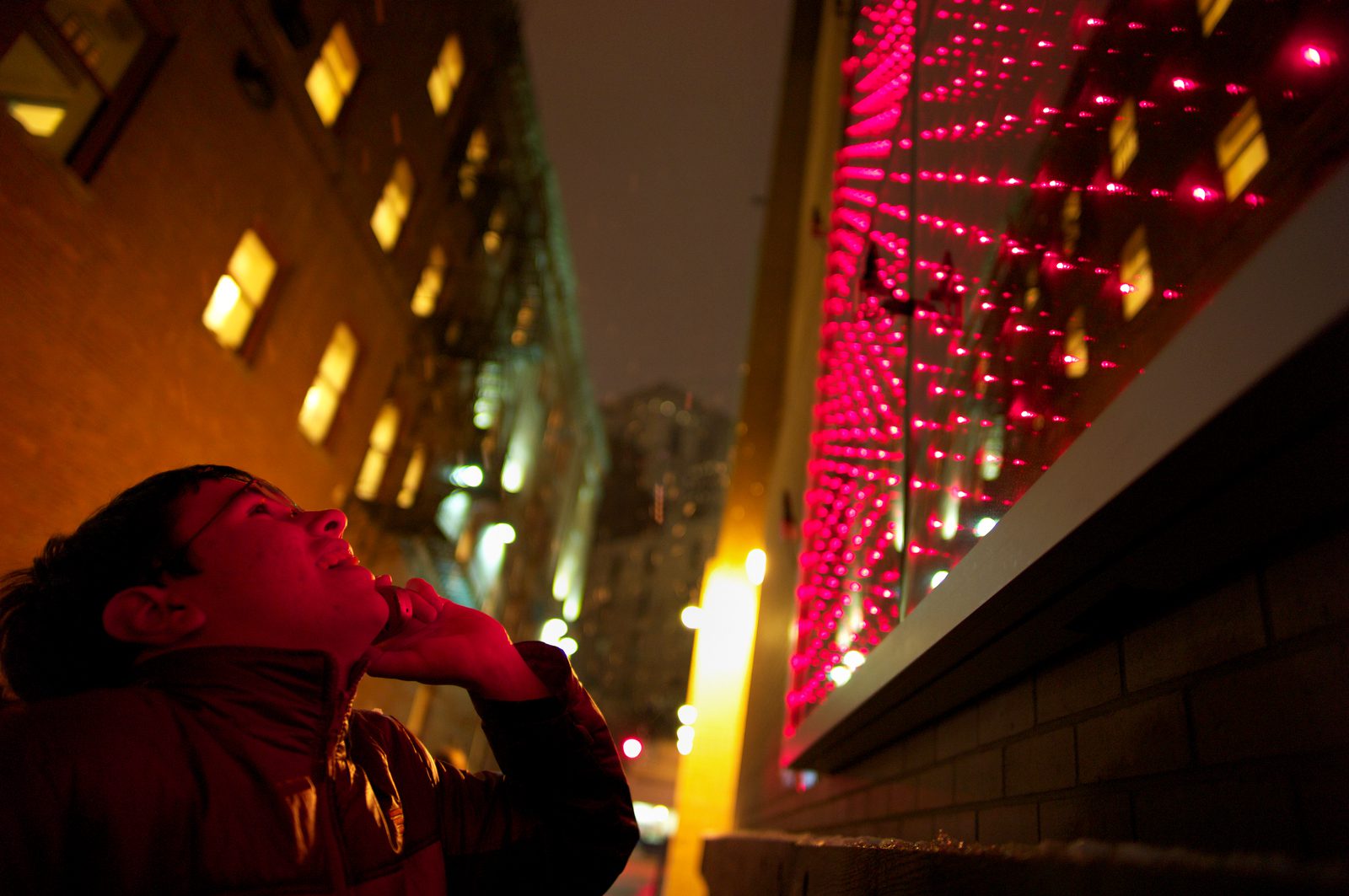 man looking at a light art installation in the cultural district of pittsburgh at night