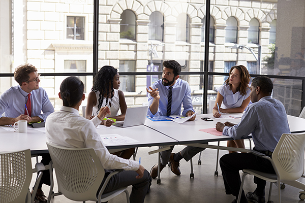 Group of young professionals sitting around a conference table  