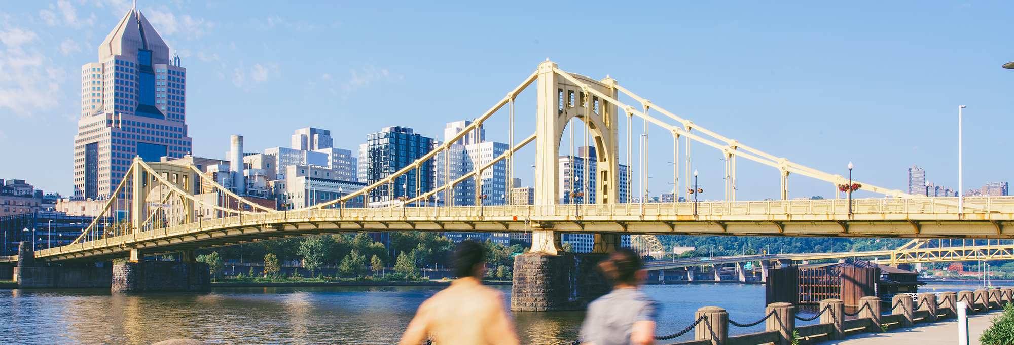 Runners jogging alongside the Roberto Clemente Bridge in Pittsburgh 