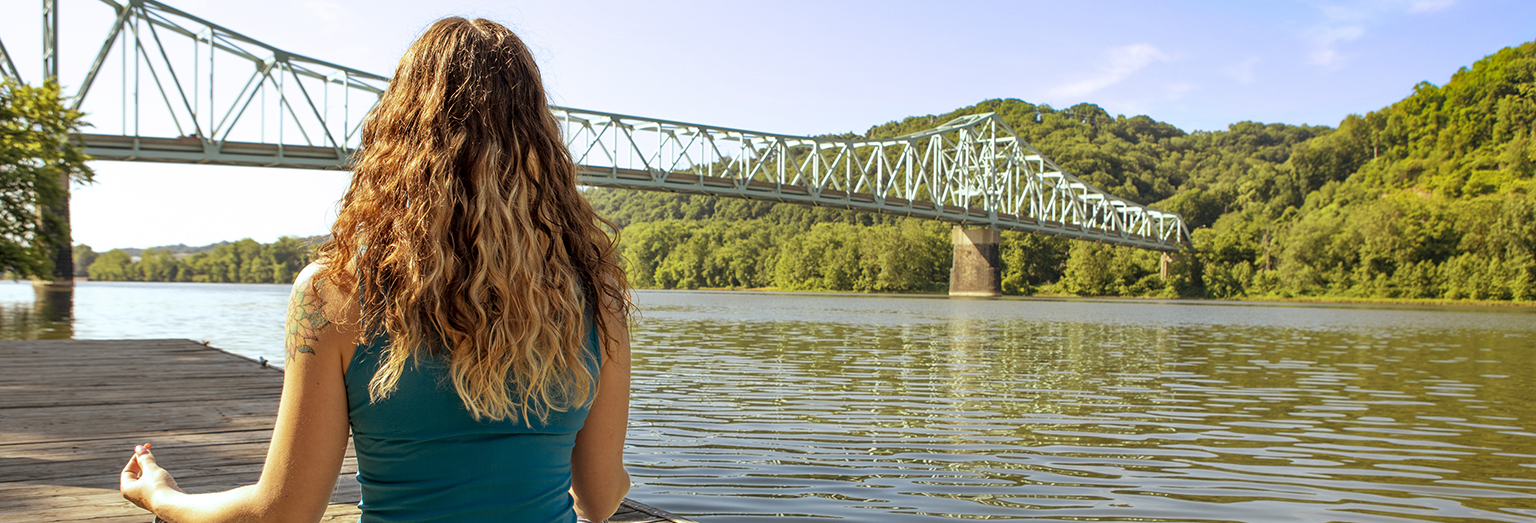 A young woman doing yoga by Sewickley Bridge in western Pennsylvania