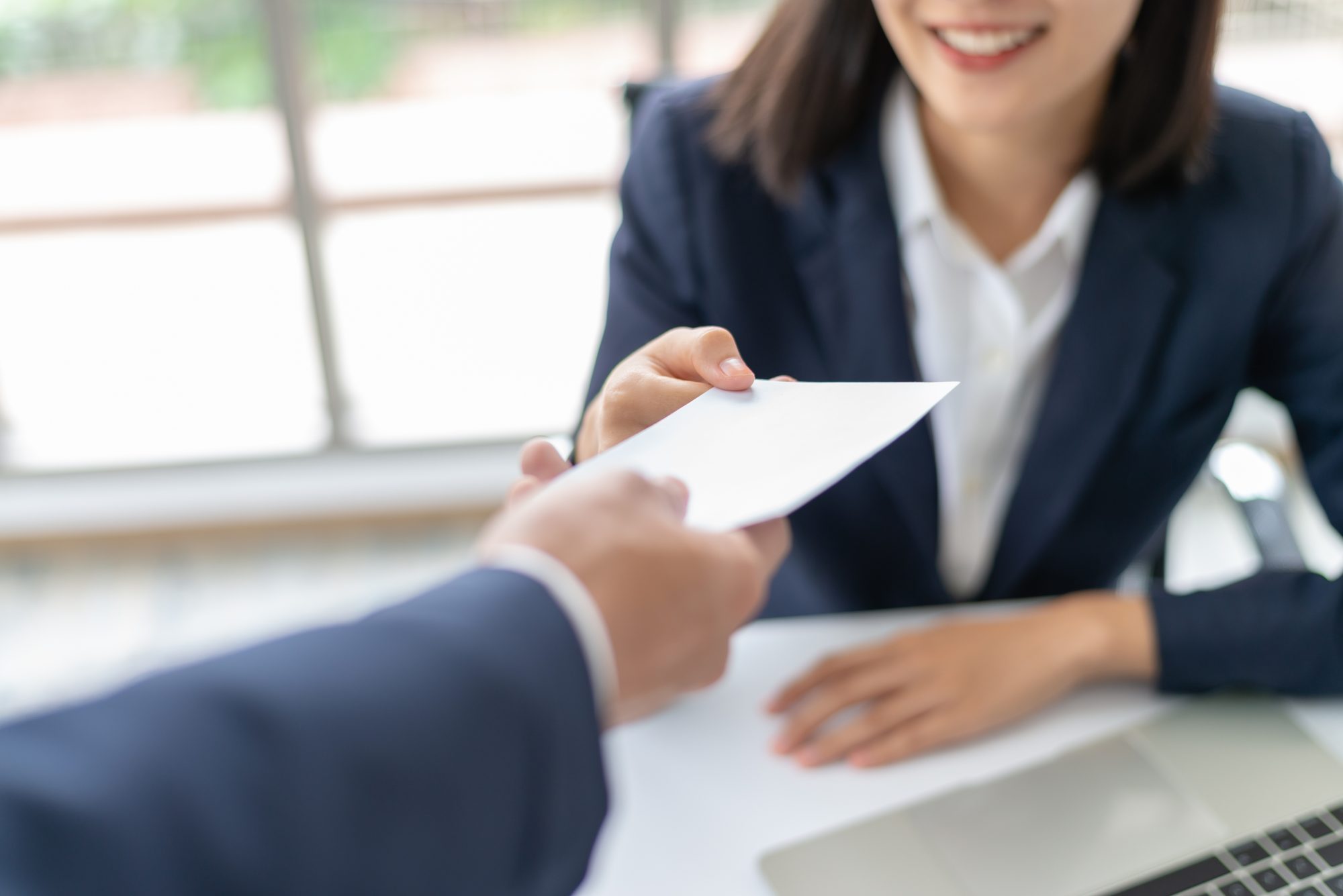 Happy young woman receiving a bonus or check from management