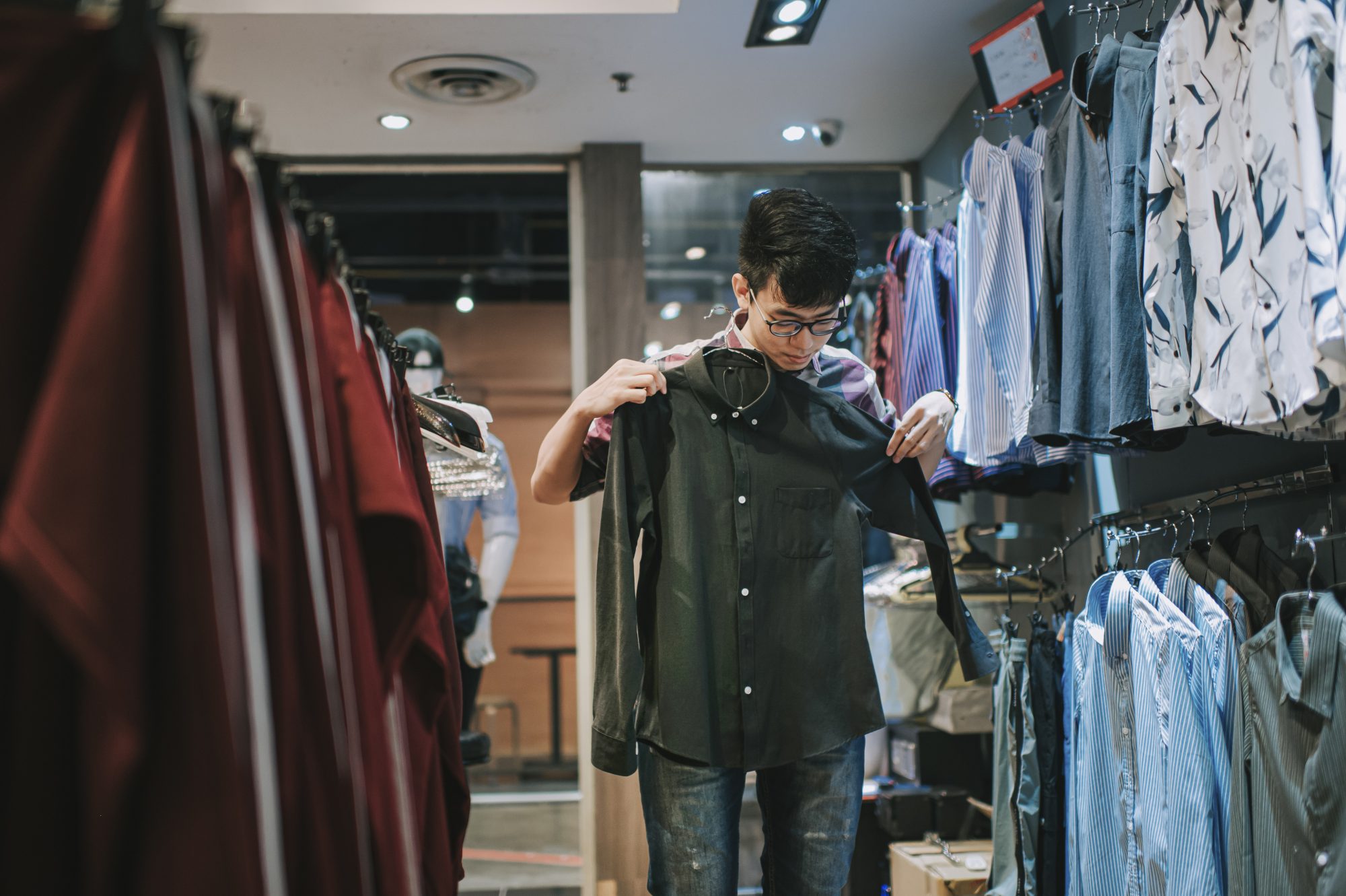 A young man shopping for a shirt