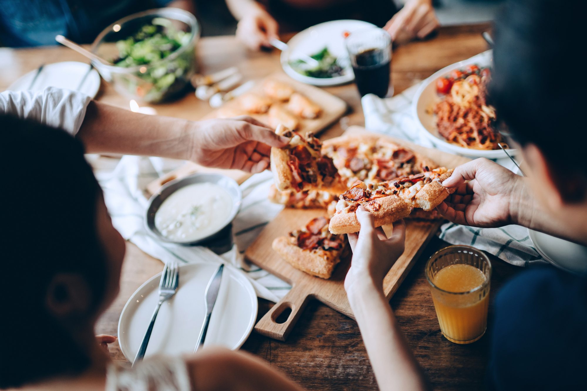 Closeup of young group of friends eating pizza