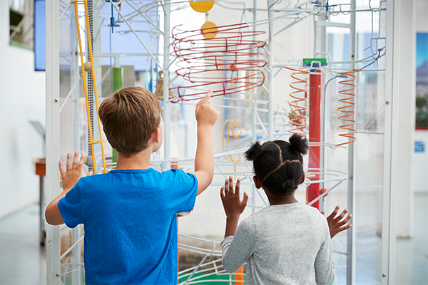 Two kids looking at a science exhibit