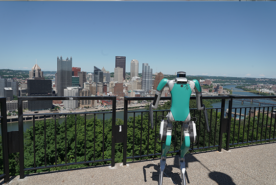 An Agility robot standing in front of downtown Pittsburgh.