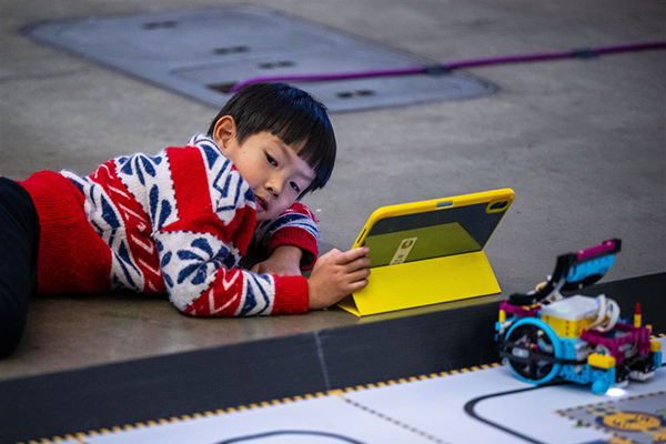 Child lies on the ground and watches a iPad