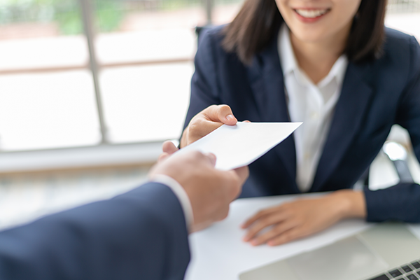 Man handing woman an envelope